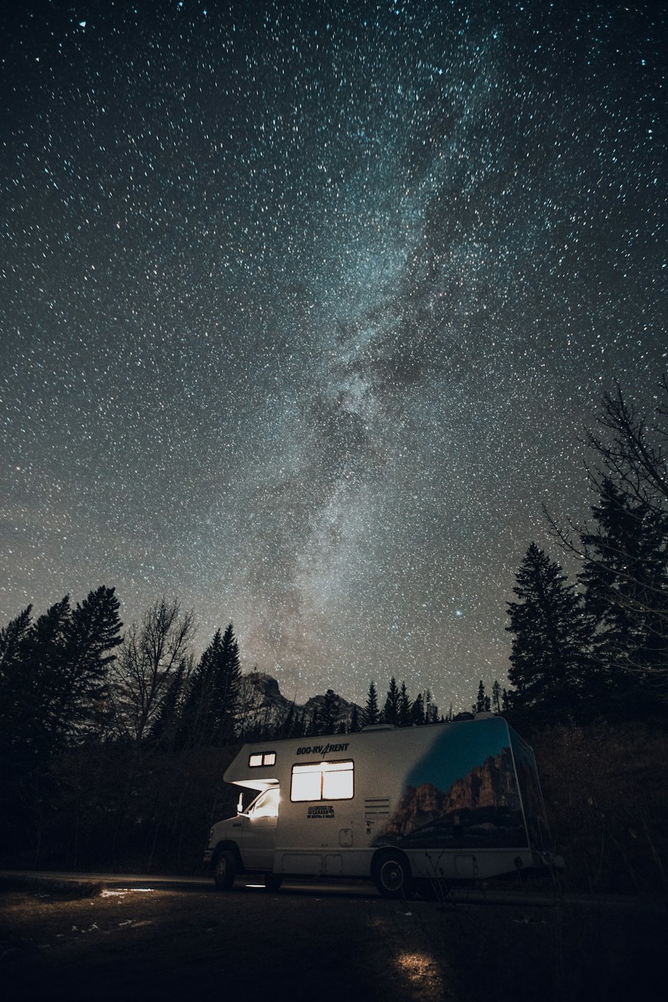 Motorhome parked at night under a starry sky.